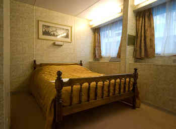 В спальне: двуспальная кровать, шкаф для одежды, два обзорных окна, фен.
